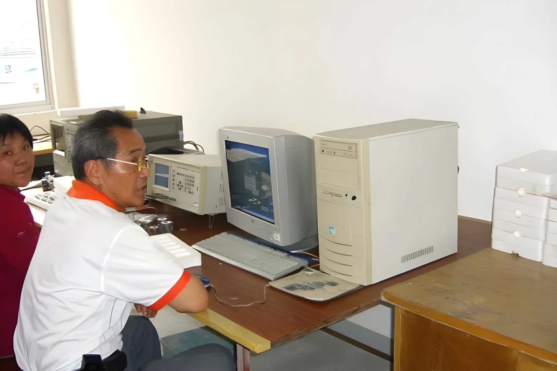 Yujie-Ingenieursarbeit mit Laborinstrumenten und Desktop-Computern in den frühen 2000er-Jahren