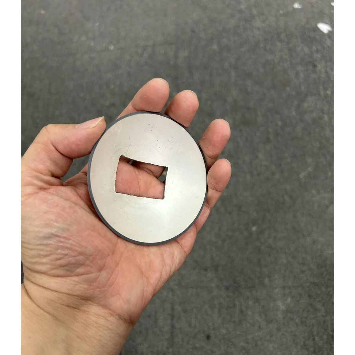 Keramik mit quadratischer Apertur und kugelförmiger Kappe zur Maßstabsveranschaulichung in der Hand dargestellt
